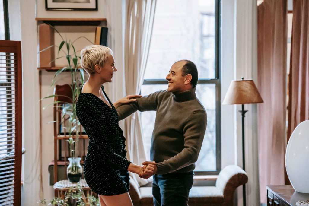 Un homme souriant danse avec une partenaire dans une ambiance conviviale